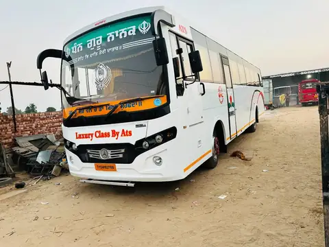 Luxury coach, white with Punjabi livery, front three-quarter view — built by Guru Kirpa Bus Body Builders, Barnala